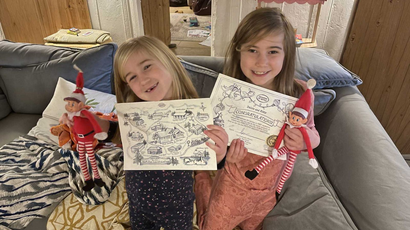 Children holding personalised International Elf Service Christmas letters and elves