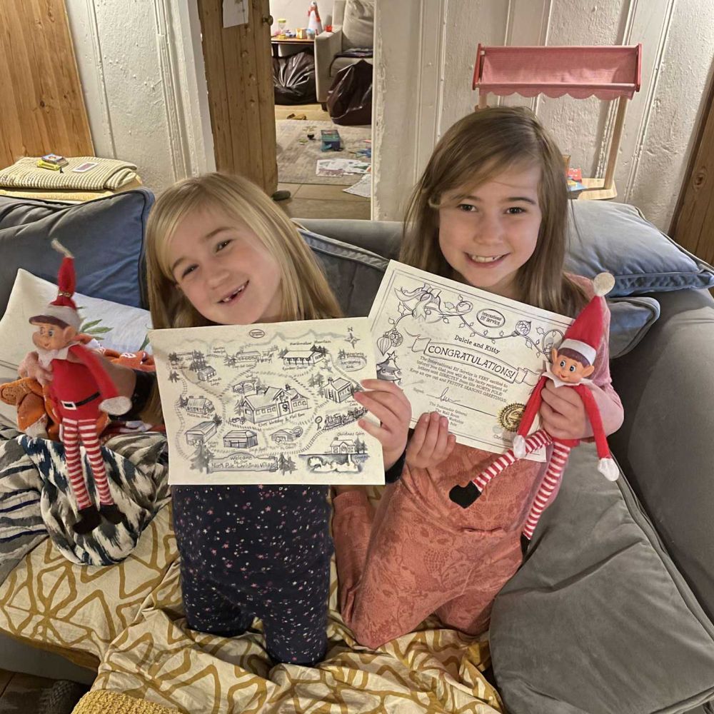 Children holding personalised International Elf Service Christmas letters and elves